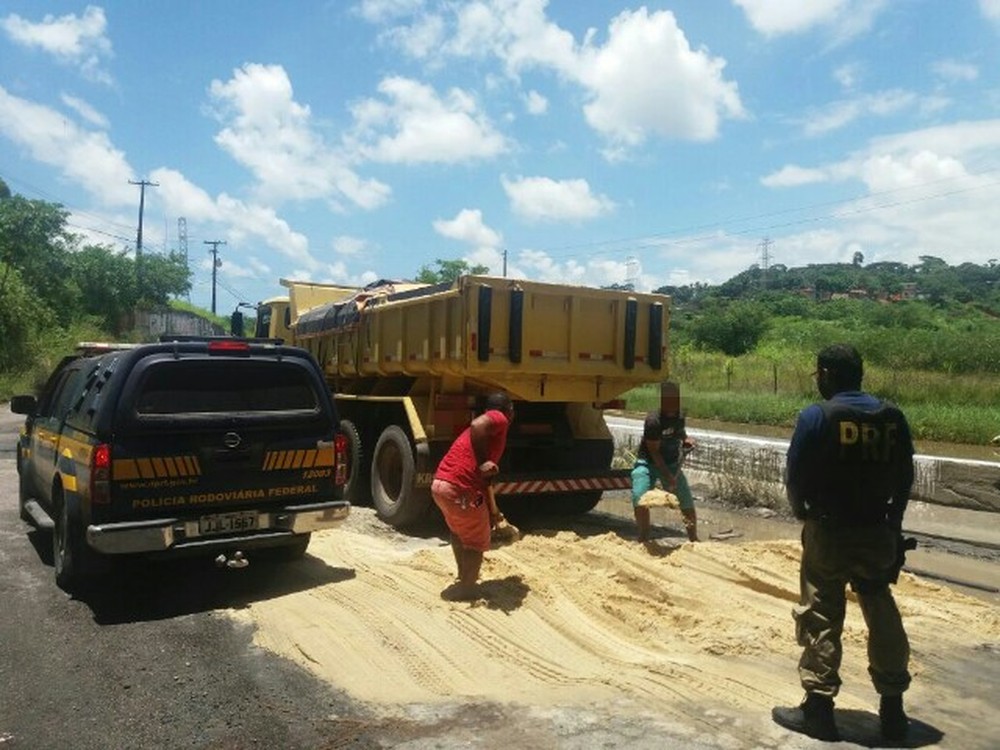 Motorista de caminhão joga areia em BR no Grande Recife para tentar fugir de multa por excesso de peso