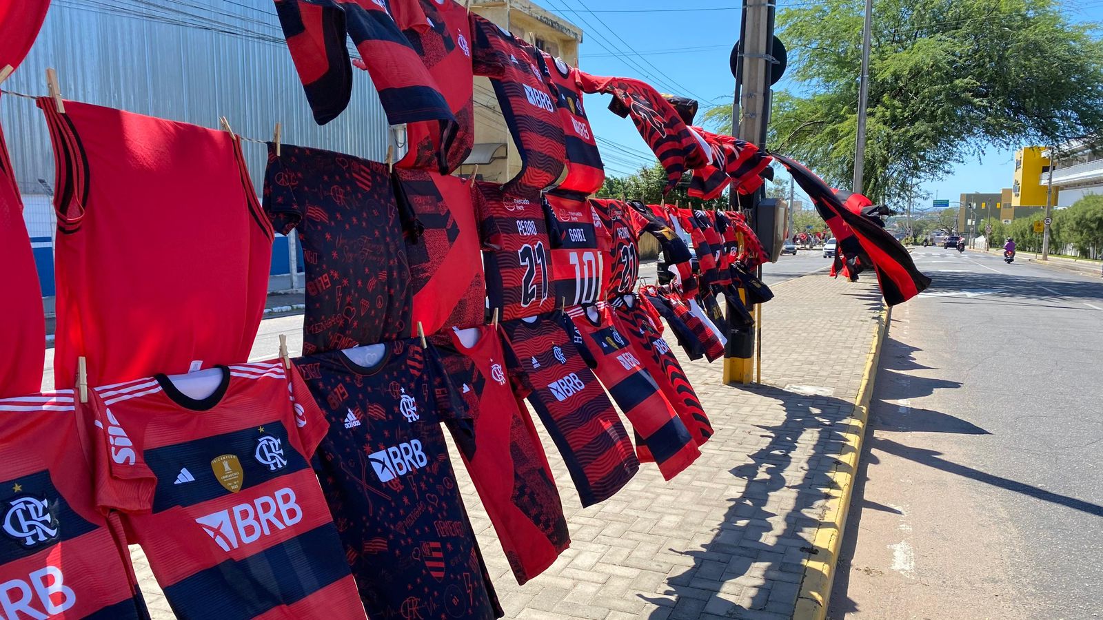 Vendedor de Alagoas comercializa camisas e bandeiras do Flamengo às vésperas do jogo na Arena Romeirão